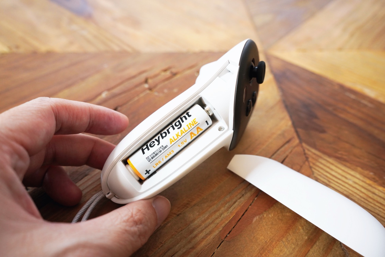 コントローラーのカバーを開け、単三電池を確認する様子