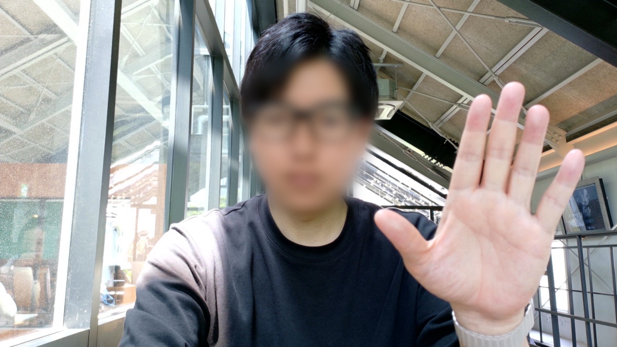 手のひらを向ける人物