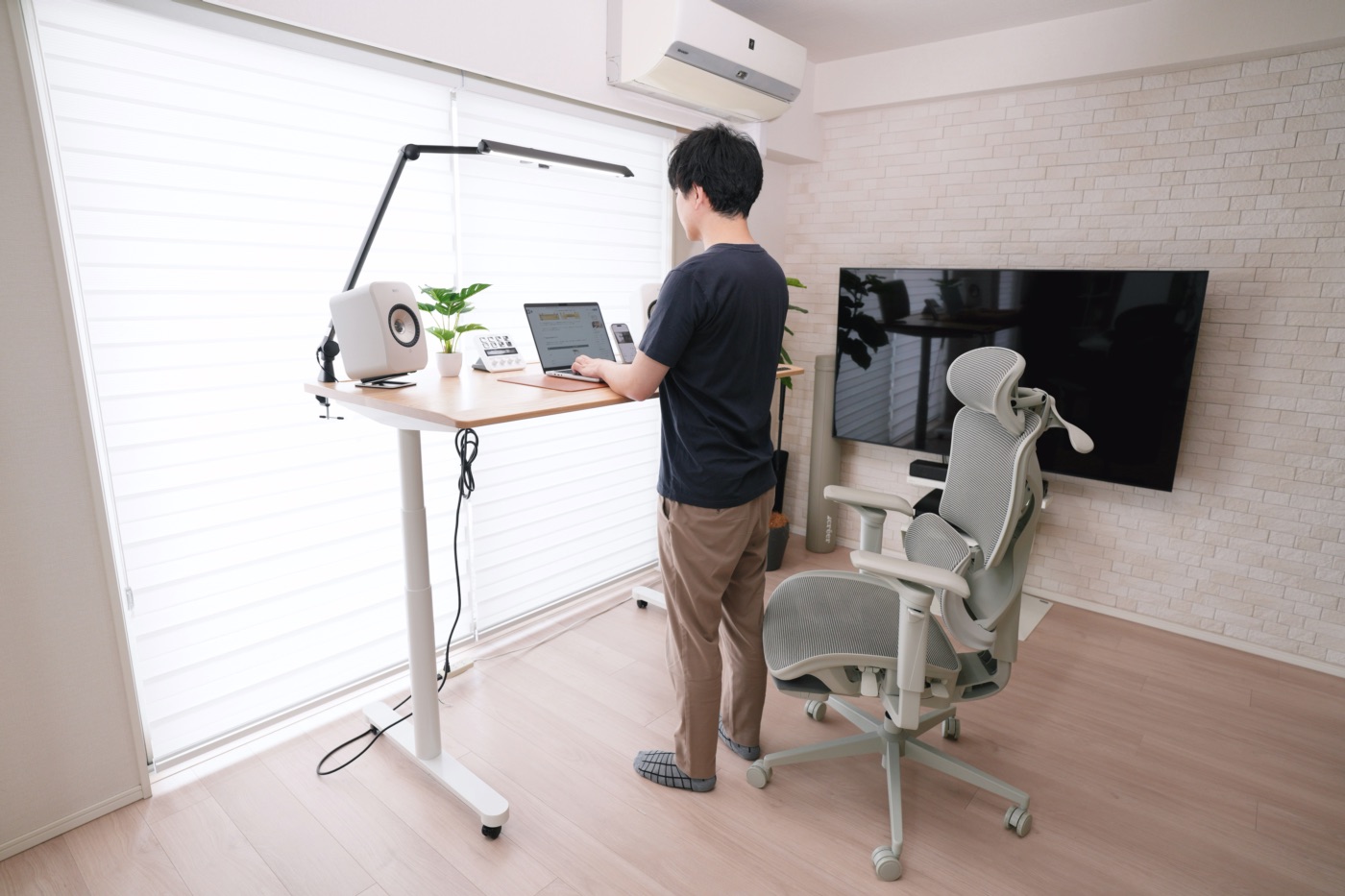 立ち上がってPC作業をする男性