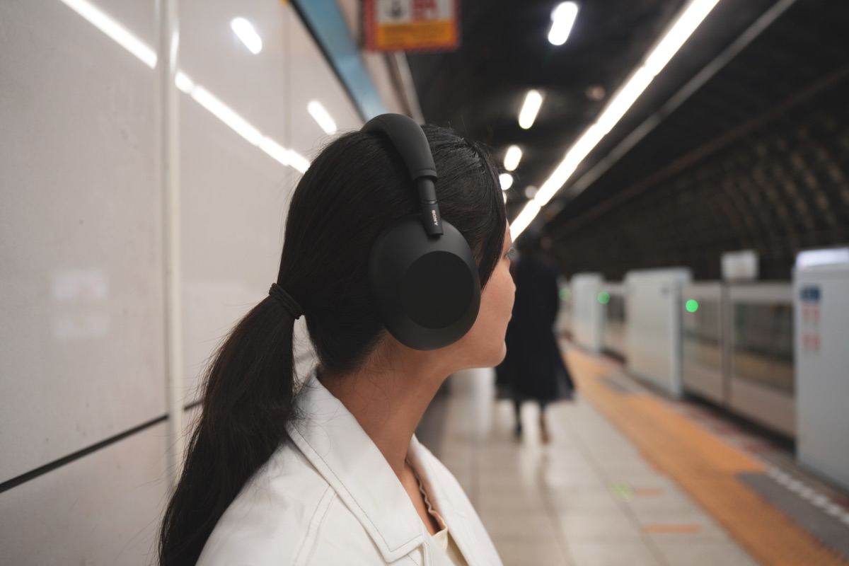 駅のホームで音楽を聴く女性