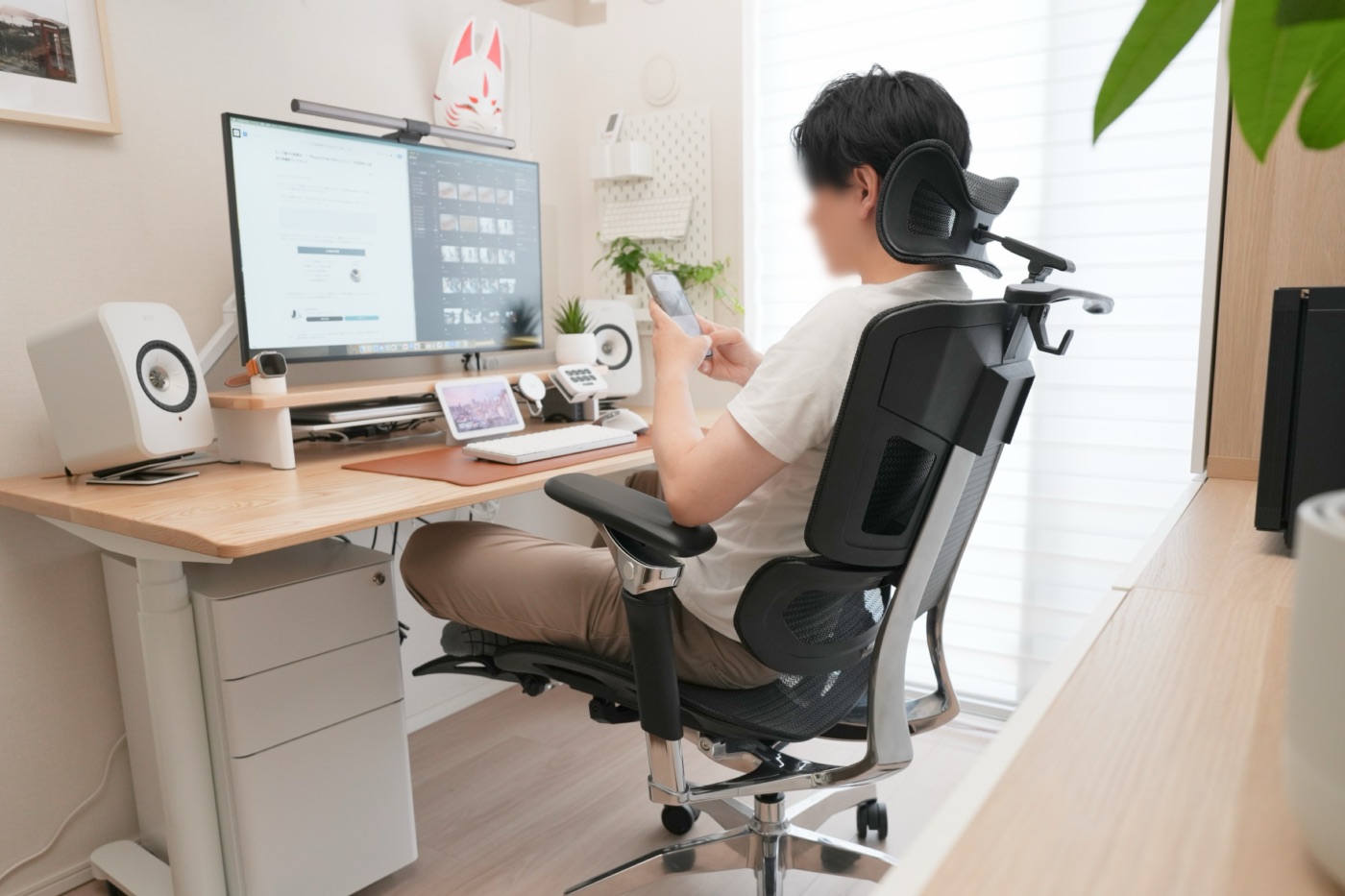 Rasical Chair Eliteに座りスマホを触る筆者