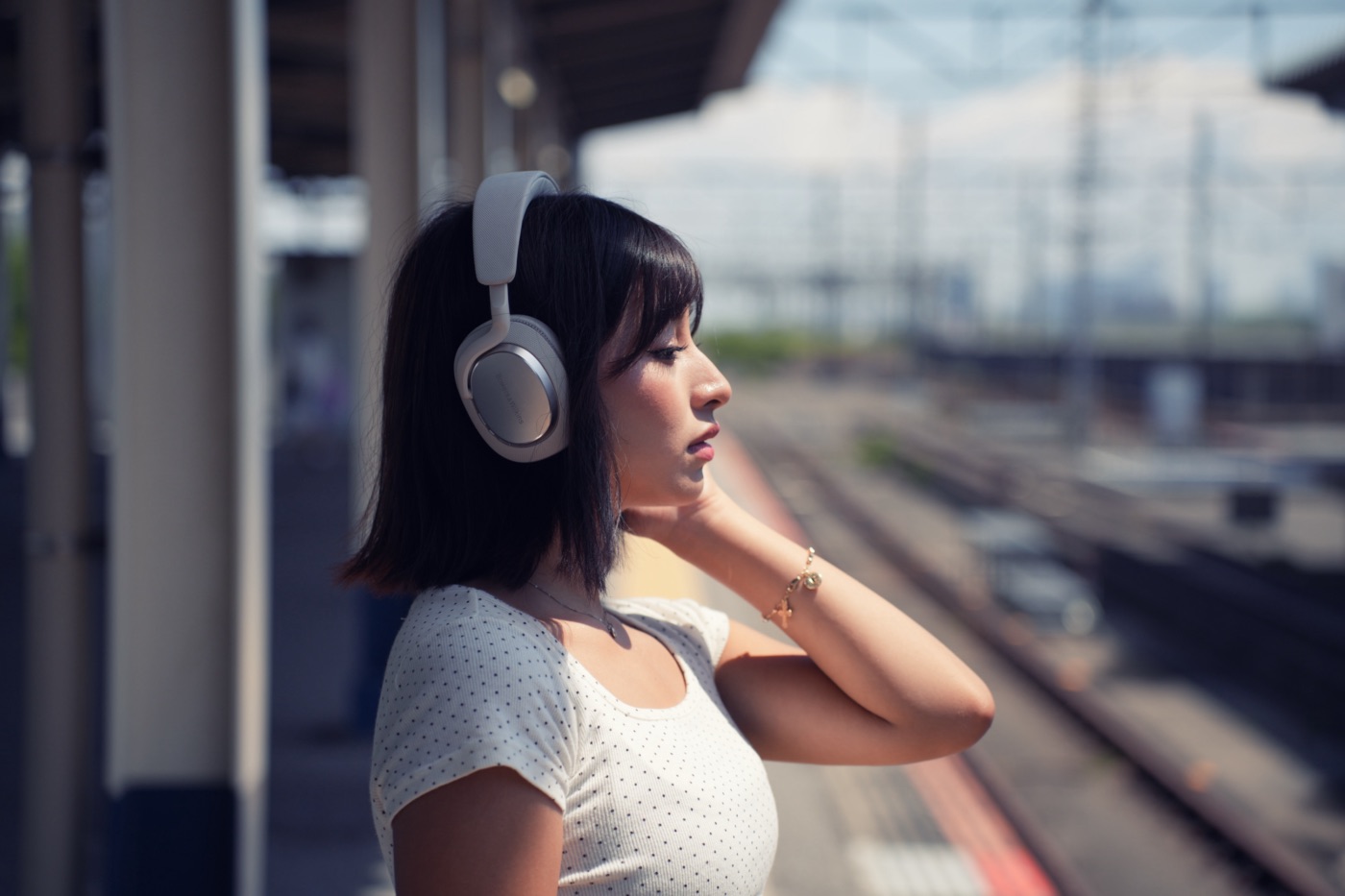 駅のホームで音楽を聴く女性