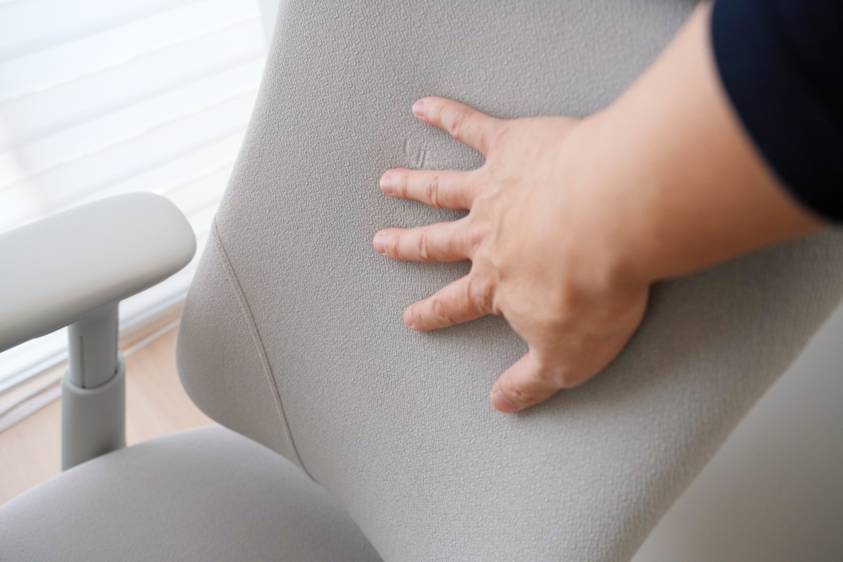 LiberNovo Omniの背もたれを手で押さえる筆者