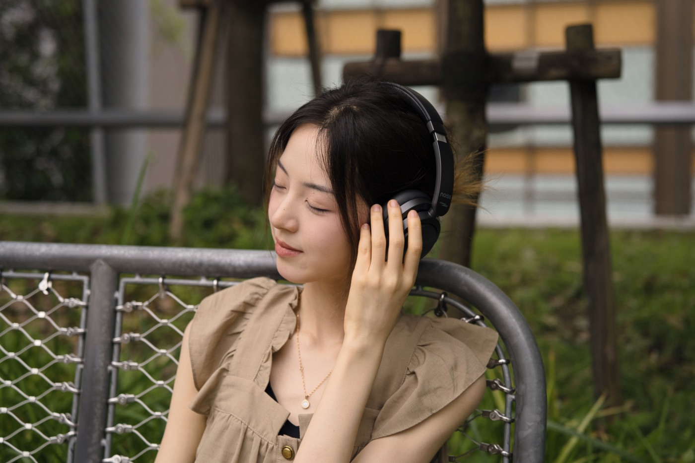 目を瞑り、Noise Master Buds MAXから流れる音に浸る女性