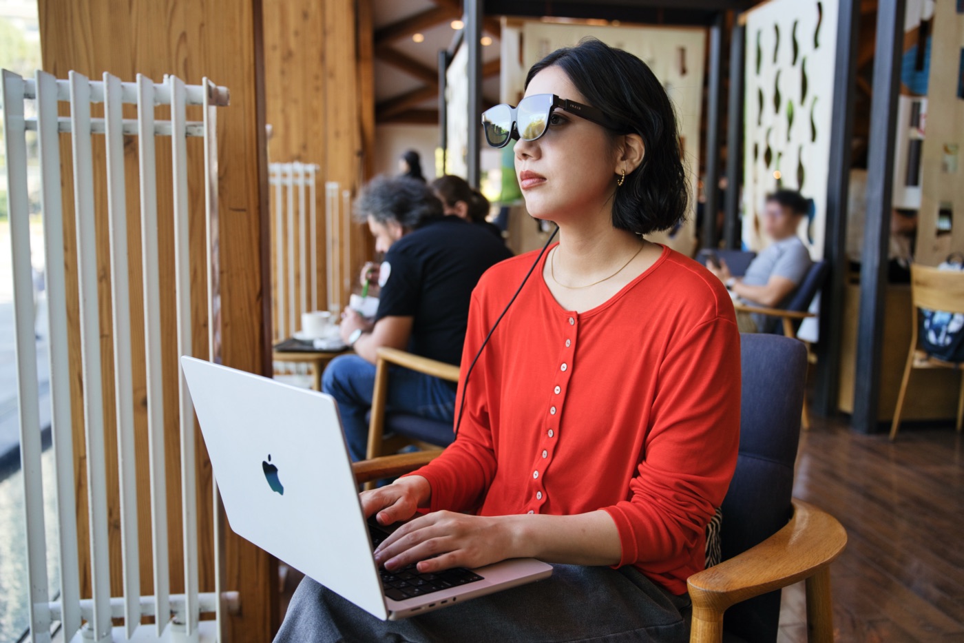 膝に乗せたMacBookに直接INAIR 2 Proを接続して作業をする女性